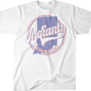 May include: White t-shirt with a red and blue circle graphic featuring the state of Indiana and the text "Indiana The Hoosier State".