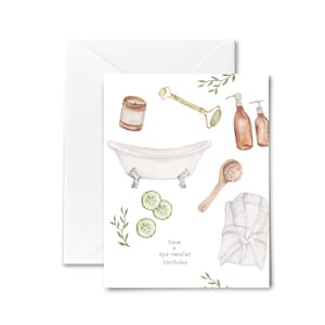 May include: A watercolor illustration of a spa birthday card with a bathtub, candles, cucumber slices, a bathrobe, and a wooden spoon with a loofah. The text reads "have a spa-tacular birthday".