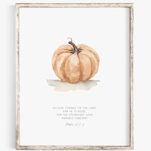 May include: A framed wall art print featuring a watercolor illustration of a light orange pumpkin centered above the text: OH GIVE THANKS TO THE LORD, FOR HE IS GOOD, FOR HIS STEADFAST LOVE ENDURES FOREVER! Psalm 107:1. The frame is light wood.