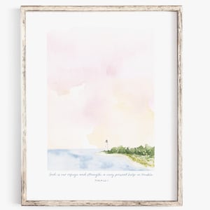 May include: Watercolor print of a coastal scene with a lighthouse, trees, and water. The sky is a blend of pink and yellow hues. The framed art piece includes the text "God is our refuge and strength, a very present help in trouble. Psalm 46:1."