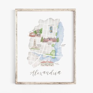 May include: A watercolor illustration of a map of Alexandria, Virginia. The map features landmarks like the Old Town Alexandria, the Torpedo Factory Art Center, and the George Washington Masonic National Memorial. The map is framed in a light wood frame.