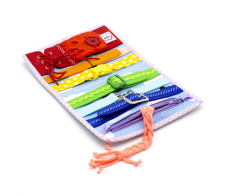 Puede incluir: Un libro de actividades de tela con colores de arco&iacute;ris con varias texturas y cierres para ni&ntilde;os. Cuenta con una cremallera, cordones, hebillas y un bot&oacute;n. El libro est&aacute; hecho de tela suave y es perfecto para desarrollar la motricidad fina.