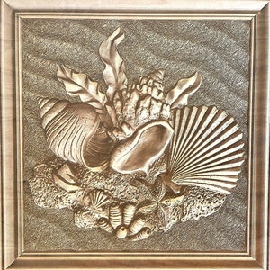 Może przedstawiać: Rzeźba z drewna w ramie przedstawiająca muszle i wodorosty. Rzeźba jest w odcieniach brązu i beżu i ma fakturowaną powierzchnię.