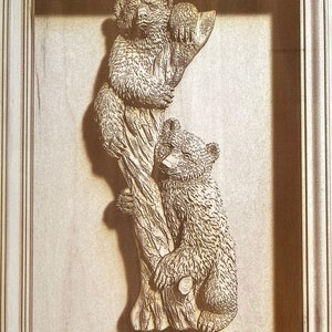 May include: A wooden carving of two bears climbing a tree. The bears are brown and have detailed fur. The tree is carved with bark and branches.