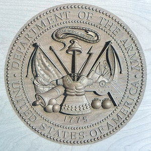 May include: A circular seal with the words "Department of the Army, United States of America" around the edge. The seal features a shield with crossed cannons and a snake with the words "This We'll Defend" above it. The year 1775 is inscribed below the shield.