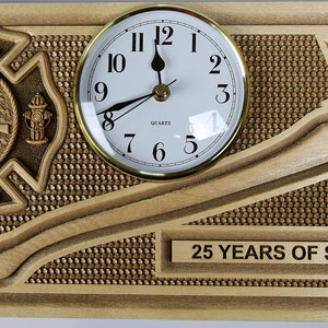 May include: A wooden plaque with a firefighter's emblem, a clock, and a fire axe. The plaque is engraved with "FIREFIGHTER JOHN REYNOLDS", "BLAUVELT FIRE DEPARTMENT", and "25 YEARS OF SERVICE".