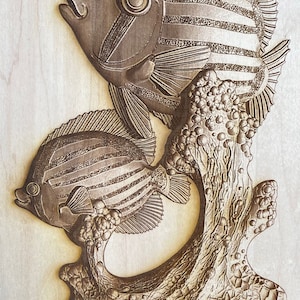 May include: Two intricately carved wooden fish with striped patterns, perched on a detailed wooden coral base. The fish are brown and have realistic features, including eyes and fins.