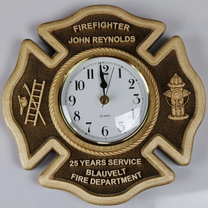 May include: A wooden firefighter clock with a brown and tan finish. The clock is shaped like a fire department Maltese cross. The clock face is white with black numbers and hands. The clock has the text "FIREFIGHTER JOHN REYNOLDS 25 YEARS SERVICE BLAUVELT FIRE DEPARTMENT" on it.