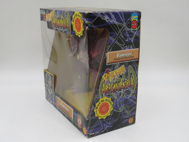 May include: A red and brown wind-up toy spider with the name "Vampider" and the text "Chomp and Flap Action!" on the box. The box is black with a spider web design and the words "Spider-Man Arachniphobia" on it.