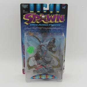 Peut inclure: Un emballage en plastique contenant une figurine Manga Spawn Ultra-Action. La figurine est blanche et bleue avec un projectile de slime vert. L'emballage a un fond bleu avec les mots "Manga Spawn Ultra-Action Figures" imprimés dessus. La figurine est un personnage Violator. L'emballage indique "Lancez du slime depuis la catapulte et rangez-le dans la cage thoracique !"