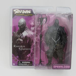 Puede incluir: Un paquete de plástico que contiene una figura de acción de Raven Spawn de la serie animada Spawn. La figura es negra y gris con una capa morada y un casco plateado. La figura sostiene un bastón plateado. El paquete es morado y negro con las palabras "Spawn: The Animated Series" y "Raven Spawn" impresas en él.