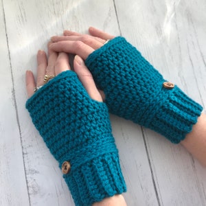 May include: Teal blue crocheted fingerless gloves with brown button accents.