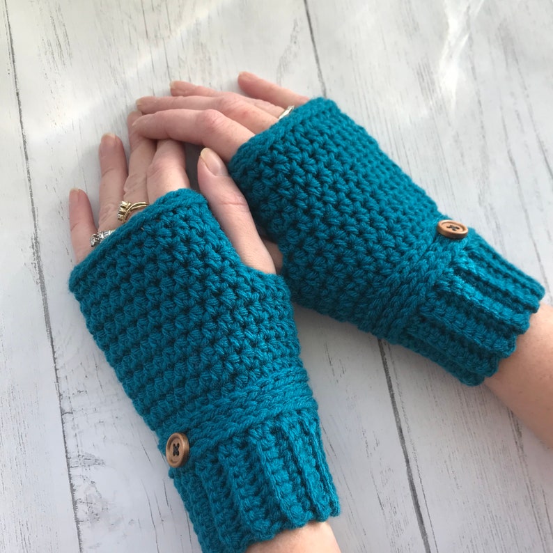 May include: Teal blue crocheted fingerless gloves with brown button accents.