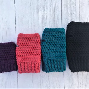 May include: Four pairs of crocheted fingerless gloves in different colors: purple, pink, teal, and black.
