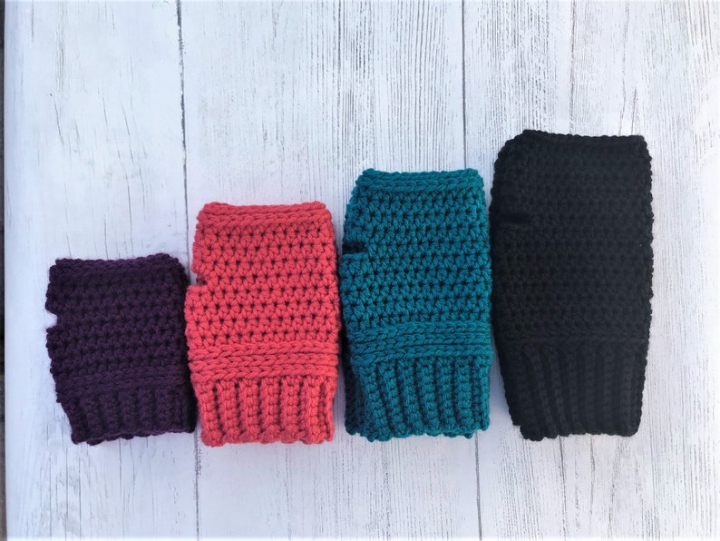 May include: Four pairs of crocheted fingerless gloves in different colors: purple, pink, teal, and black.