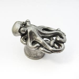 May include: A silver octopus-shaped cabinet knob with a detailed design. The octopus is curled up with its tentacles intertwined.