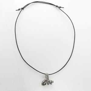 May include: A silver bee pendant necklace on a black leather cord.