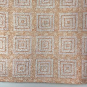 May include: A beige quilt with a white geometric pattern of squares within squares.