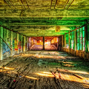 May include: A long, abandoned hallway with graffiti on the walls and broken windows. The floor is covered in debris and dust. Sunlight streams in through the windows, creating a dramatic effect.