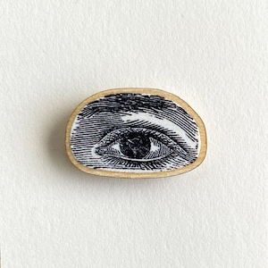 May include: Vintage Medicine Eye illustration on a wooden pin with a white background. The pin is on a card that says "Vintage Medicine" at the top and "POP Arts & Crafts" at the bottom.
