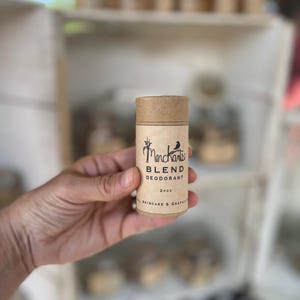 K&ouml;nnte beinhalten: Ein zylindrischer Deodorant-Stick mit einer braunen Pappr&ouml;hre und Kappe. Das Etikett lautet "Merchants Blend Deodorant" mit einer kleinen Vogelgrafik. Das Produkt ist 57g und tr&auml;gt die Aufschrift "Natural Skincare & Graphics".