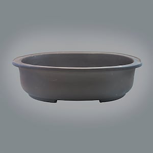 May include: A brown oval ceramic bonsai pot with a slightly raised rim and three small feet on the bottom.