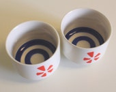 Pair Bullseye Sake Tasting Cups Japanese Import Ceramic Kotobuki Style Porcelain Japan Orange Five Petal Flower Logo