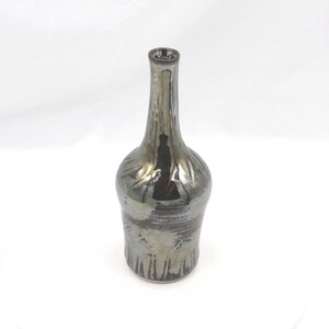 May include: A silver and brown ceramic vase with a narrow neck and a wide base. The vase has a textured surface and a glossy finish.