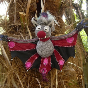 Little hanging Bat with bendable wings and a feather in its top hat!