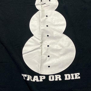 May include: Black t-shirt with a white snowman graphic and the text "TRAP OR DIE" printed below.