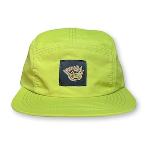 May include: A lime green 5-panel cap with a black square patch featuring a colorful graphic of a cartoon face with a crown of spikes.