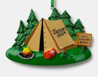 May include: A brown and tan tent with a black door and a red sleeping bag. The tent is surrounded by green trees and a campfire. A sign reads "Don't Feed The Bears!" and the tent has the name "Jason 2024" written on it. This is a personalized Christmas ornament.