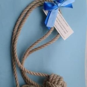 May include: A natural jute rope with a knotted end, tied with a blue ribbon bow. The rope is approximately 3 feet long.