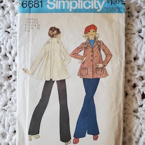 Puede incluir: Un sobre de patrón de costura Simplicity 6681 con ilustraciones de dos conjuntos. Uno muestra una chaqueta blanca acampanada con pantalones negros, y el otro una chaqueta roja estampada con pantalones azules y una boina roja. Incluye el texto 6681, Simplicity y tallas.