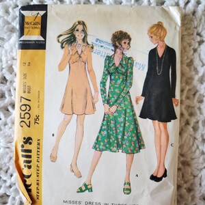 May include: A white ceramic mug with a black handle and the text "But First, Coffee" in a black, bold font. The mug is on a white surface.