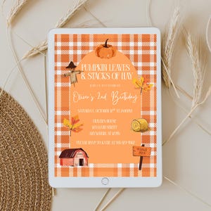 May include: A digital invitation on a tablet with a fall theme. The invitation features orange gingham and illustrations of a pumpkin, scarecrow, and hay bale. Text reads "Pumpkin Leaves & Stacks of Hay" and details for Oliver's 2nd birthday.