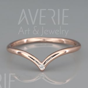 Puede incluir: Un delicado anillo de oro rosa con un pequeño diamante engastado en una banda en forma de V. El anillo es simple y elegante, perfecto para el uso diario.