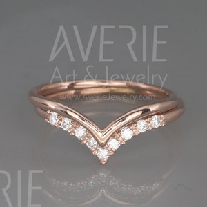 May include: Rose gold ring with a V-shaped band and small diamonds. The ring is on a gray surface. Averie Art & Jewelry www.AverieJewelry.com