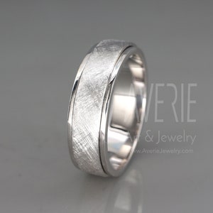 May include: A brushed silver wedding band with a beveled edge. The band has a brushed finish and a polished edge.