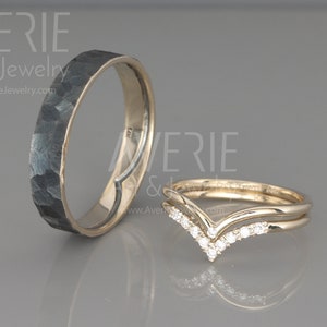 May include: Two wedding bands, one with a hammered black finish and the other a gold band with a V-shaped row of diamonds.