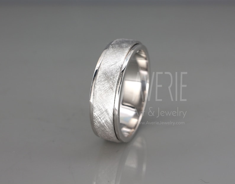 May include: A brushed silver wedding band with a beveled edge. The band has a brushed finish and a polished edge.