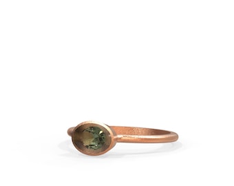 May include: A simple gold ring with a green oval gemstone set in the center.