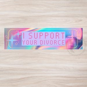 Könnte beinhalten: Ein rechteckiger Aufkleber mit dem Text "I SUPPORT YOUR DIVORCE" in einer pixeligen Schriftart. Der Aufkleber hat einen holografischen Hintergrund mit rosa, blauen und gelben Farbtönen. Dekorative Sternausbrüche und geometrische Formen umrahmen den Text.
