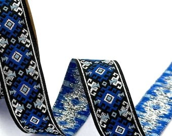 May include: Blue, black, and silver patterned ribbon with a geometric design. The ribbon is wound around a cardboard spool.