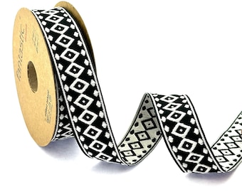 May include: Black and white patterned ribbon with a geometric design. The ribbon is wound around a brown cardboard spool with the word "Fantastic" printed on it.