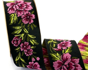 Puede incluir: Cinta negra con bordado floral rosa y verde. La cinta está tejida con un sutil patrón a rayas.