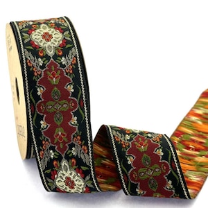 Könnte beinhalten: Eine Rolle Webband mit schwarzem Hintergrund und einem sich wiederholenden Muster aus dunkelroten, olivgrünen und goldfarbenen Blumenmotiven. Die Kanten sind mit einer dünnen, dekorativen Goldborte versehen, während die Rückseite ein orangefarbenes Muster zeigt.