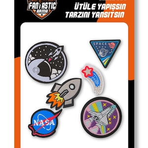 Pode incluir: Um conjunto de cinco emblemas bordados termocolantes com tema espacial, incluindo um foguete, um logótipo da NASA, um vaivém espacial, uma estrela cadente e um emblema triangular. A embalagem contém o texto FANTASTIC ARMA, IRON ON SHINE OUT, ÜTÜLE YAPIŞSIN e TARZINI YANSITSIN.