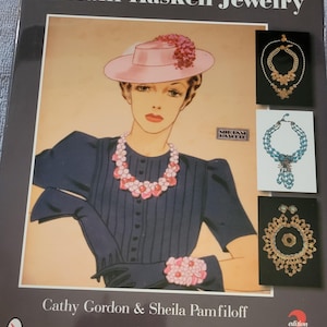 May include: A book cover titled "Miriam Haskell Jewelry" featuring an illustration of a woman wearing jewelry and a pink hat. The cover also displays jewelry designs and the names Cathy Gordon & Sheila Pamfiloff.