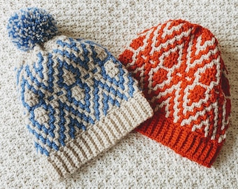 May include: Two crocheted hats, one with a blue and beige pattern and a white pom-pom, the other with an orange and beige pattern.